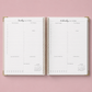 An open spiral-bound daily planner pages with gold-toned binding.